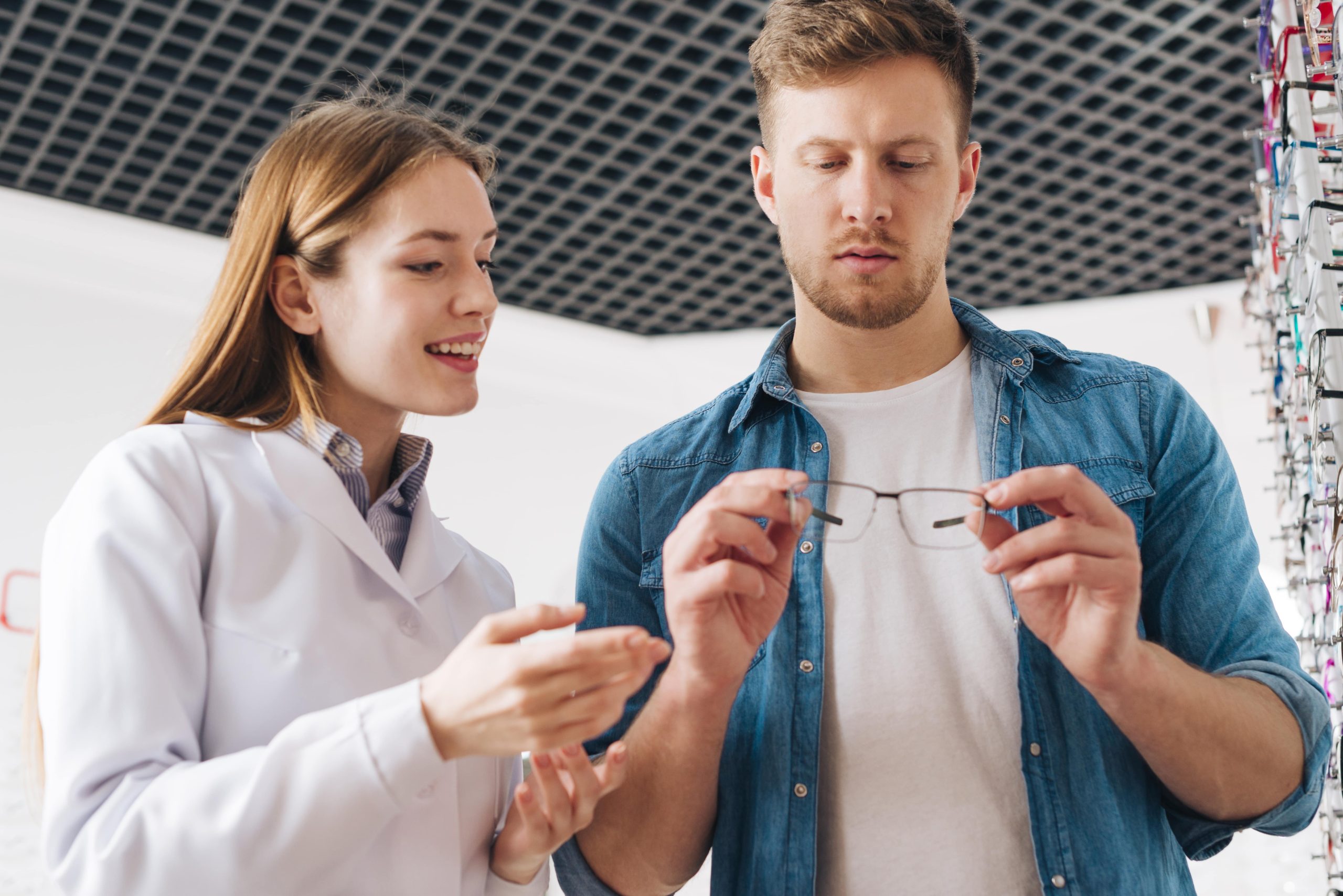 Man looking at eyeglasses with his optometrist